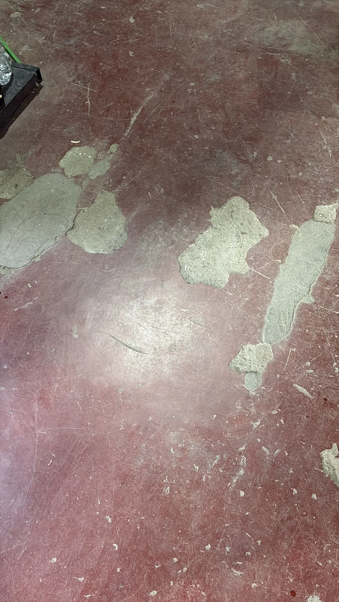 Vopsea de pardoseală exfoliată, cu zone întregi desprinse de pe beton
