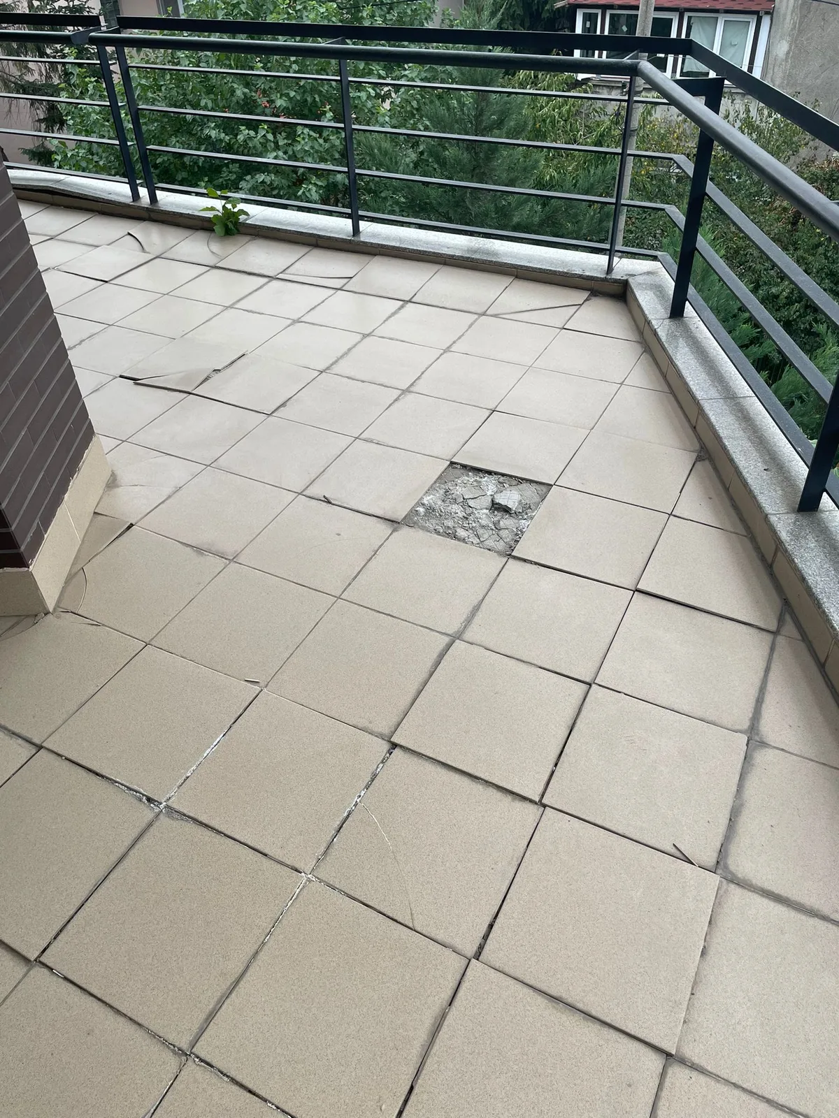 Balcon cu o placă de gresie desprinsă, lângă sifonul de scurgere