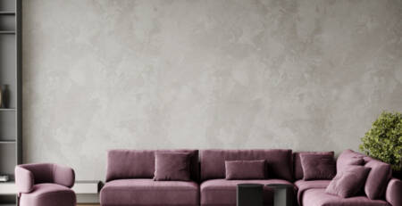 Living modern cu coltar lila si perete din microciment gri