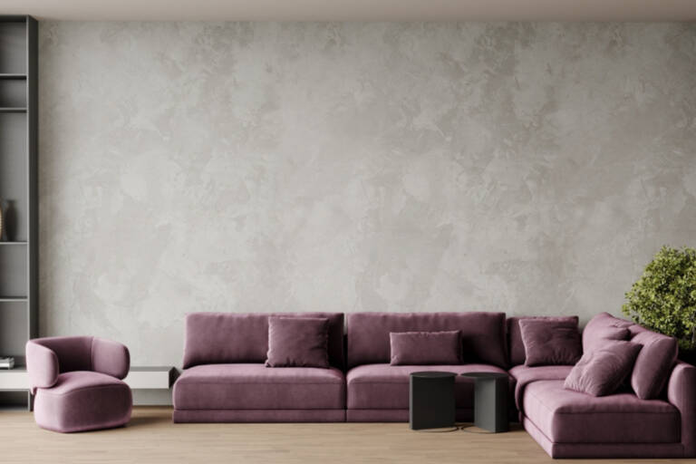 Living modern cu coltar lila si perete din microciment gri