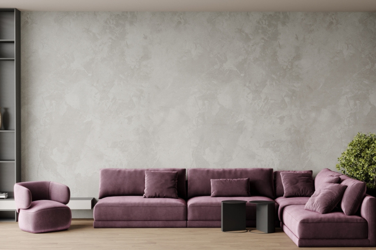 Living modern cu coltar lila si perete din microciment gri
