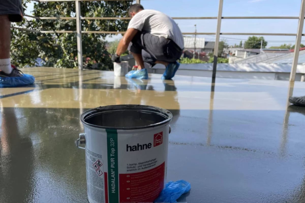 echipa de profestionist care aplica hidroizolatie pe balcon